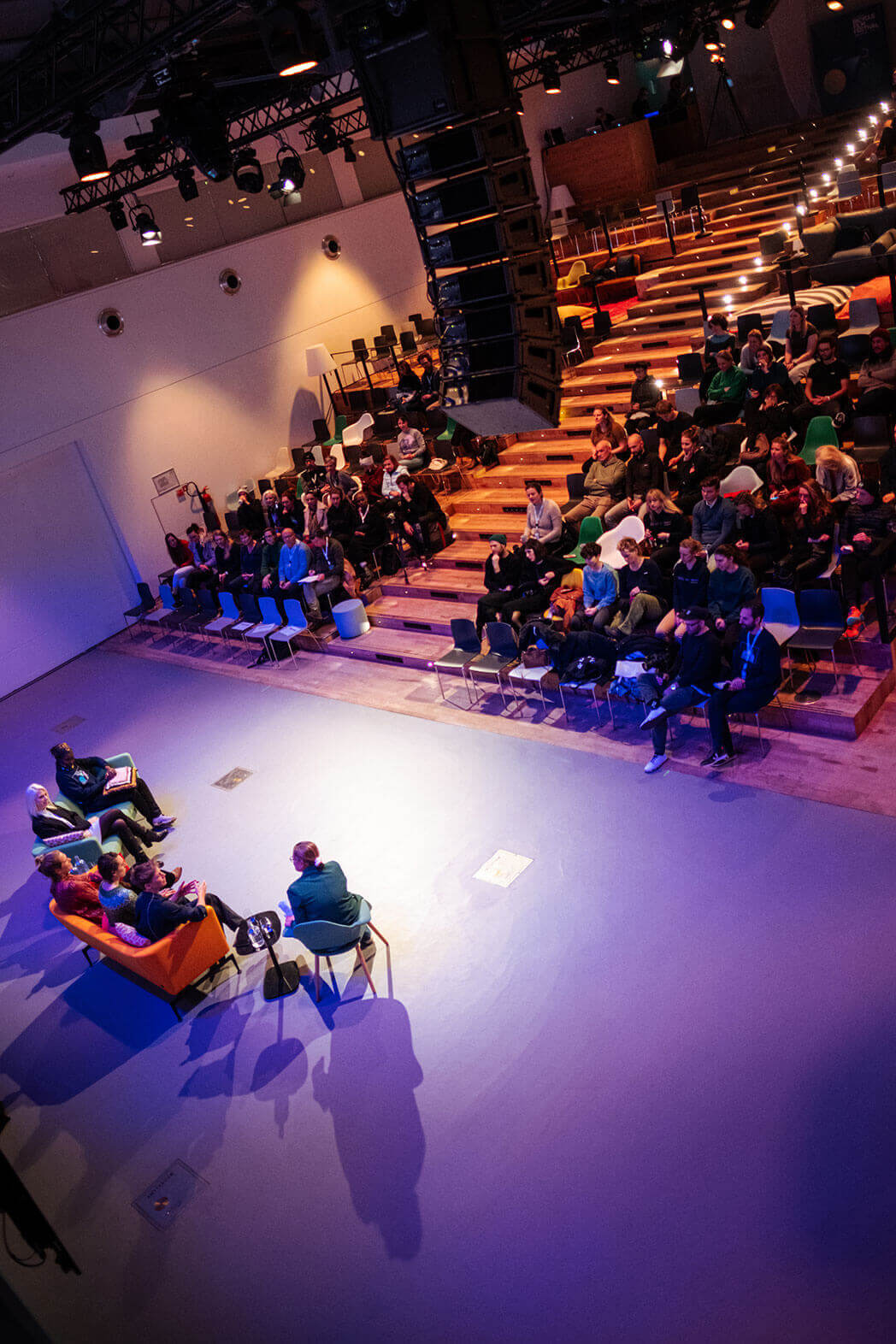 Photo of the Global IT conference, showing 6 people on the podium talking to the public watching from the stands